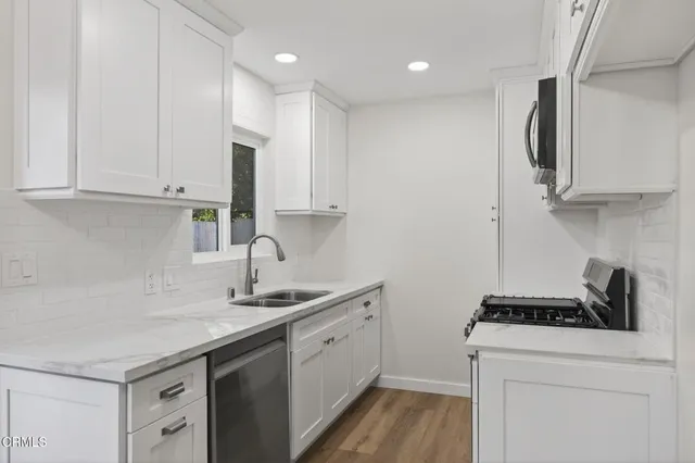 a kitchen with stainless steel appliances a stove a microwave and sink
