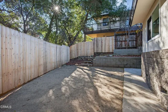 a view of a backyard with wooden fence