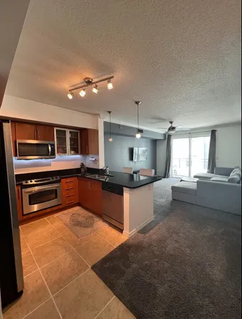 a living room with a table chairs and a kitchen