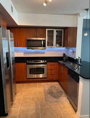 a large kitchen with stainless steel appliances kitchen island granite countertop a sink and cabinets