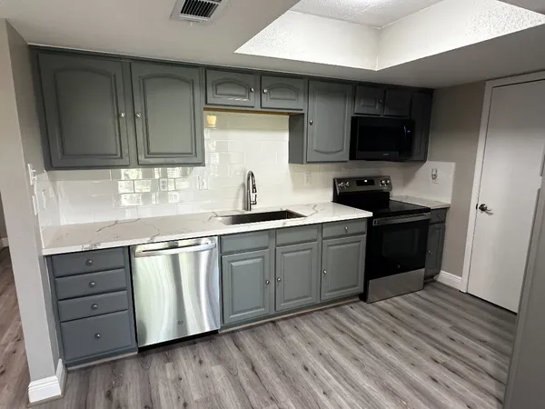 a kitchen with stainless steel appliances granite countertop a sink stove and microwave