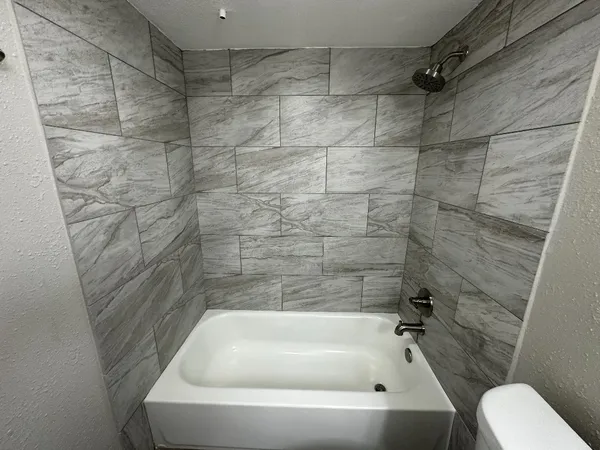 a bathroom with a white bath tub and a shower