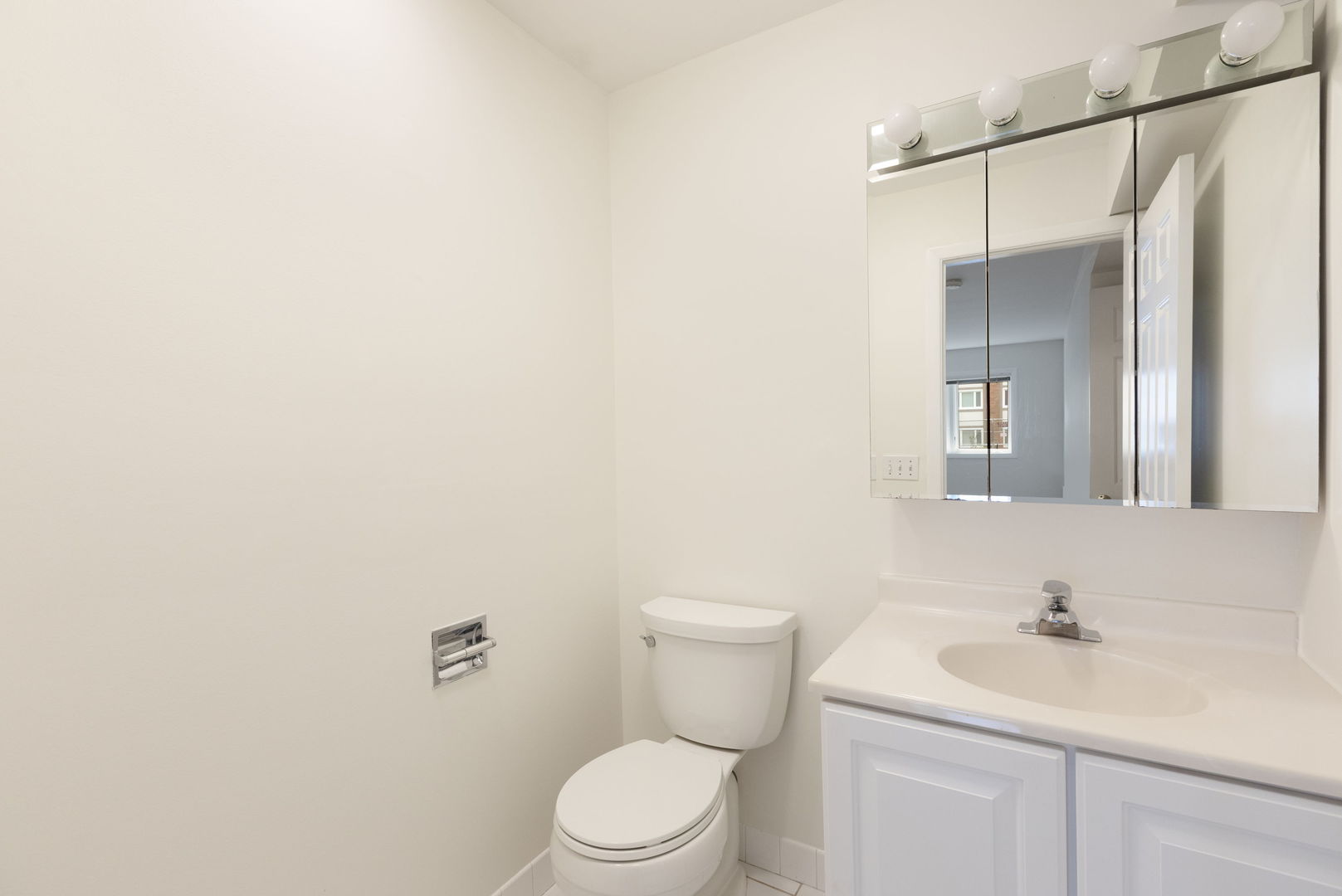 435 Ridge Road, Unit 108 Wilmette, IL 60091 - Photo 15 of 18 a bathroom with a toilet a sink and mirror