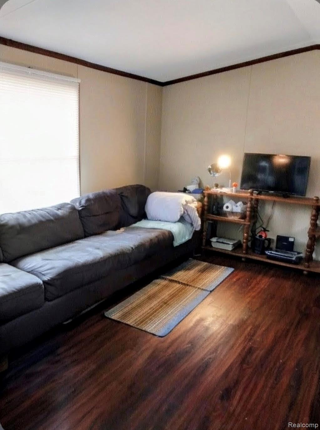 246 South Sheridan Road Lennon, MI 48449 - Photo 5 of 12 Living room featuring wood finished floors and ornamental molding