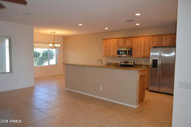 a kitchen with kitchen island granite countertop a stove a sink and a refrigerator
