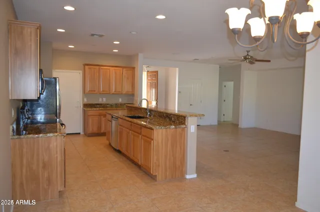 a large kitchen with stainless steel appliances a large counter top a stove a chimney a sink and a refrigerator