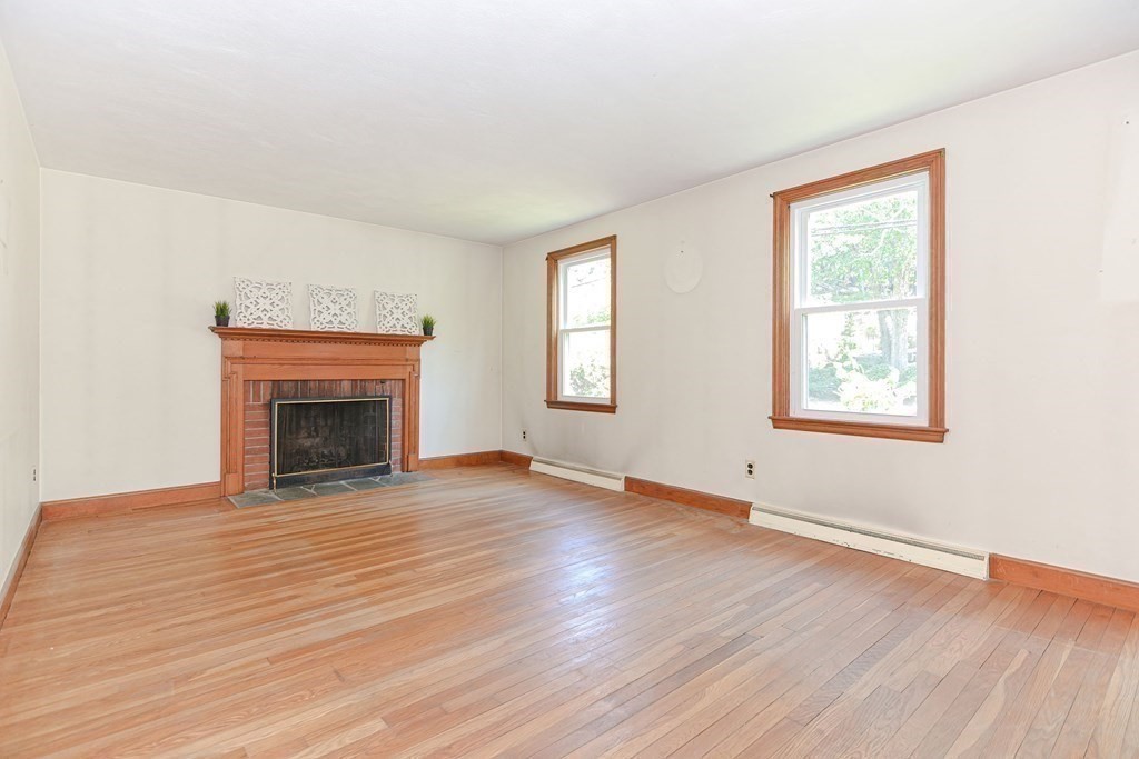 157 Vincent Road Dedham, MA 02026 - Photo 18 of 38 an empty room with wooden floor fireplace and windows