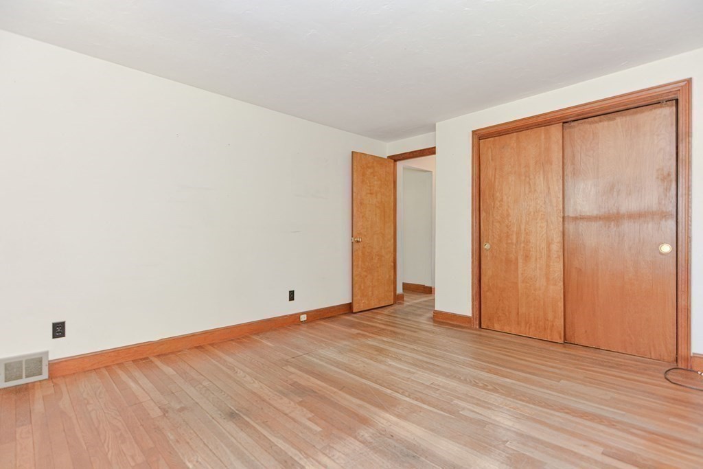 157 Vincent Road Dedham, MA 02026 - Photo 22 of 38 an empty room with wooden floor and windows with curtains