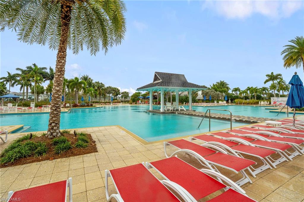 8795 Calypso Court Naples, FL 34113 - Photo 43 of 49 a view of swimming pool with outdoor seating and lake