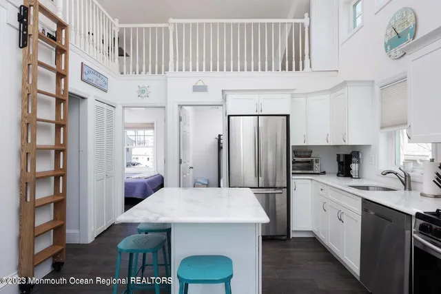 a kitchen with a sink a refrigerator and cabinets