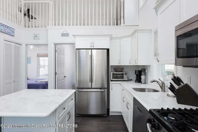 a kitchen with stainless steel appliances a stove a sink cabinets and a refrigerator