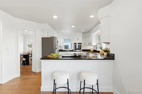 a kitchen with stainless steel appliances granite countertop a table and chairs