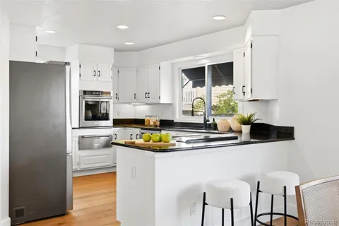 a kitchen with stainless steel appliances granite countertop a sink and a refrigerator