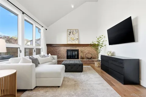 a living room with furniture a flat screen tv and a fireplace