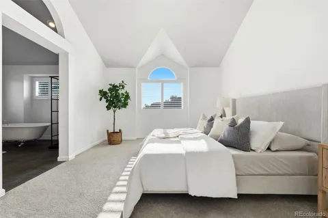 a bedroom with a bed and a potted plant