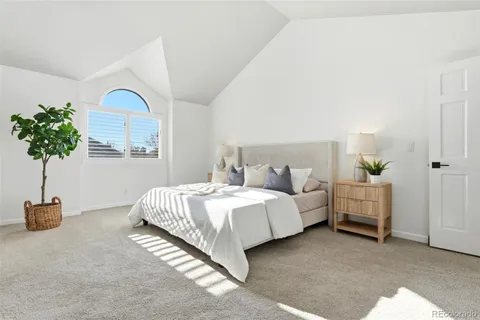a spacious bedroom with a bed and a lamp