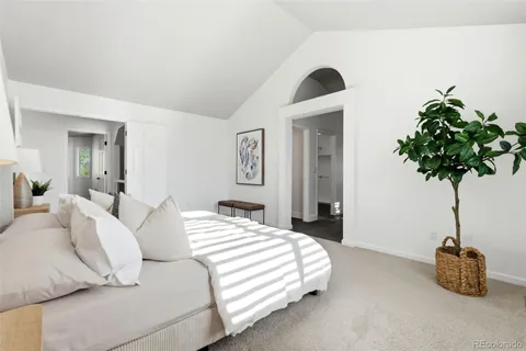 a bedroom with a bed and a potted plant