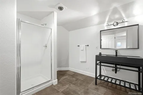 a bathroom with a sink mirror and a shower
