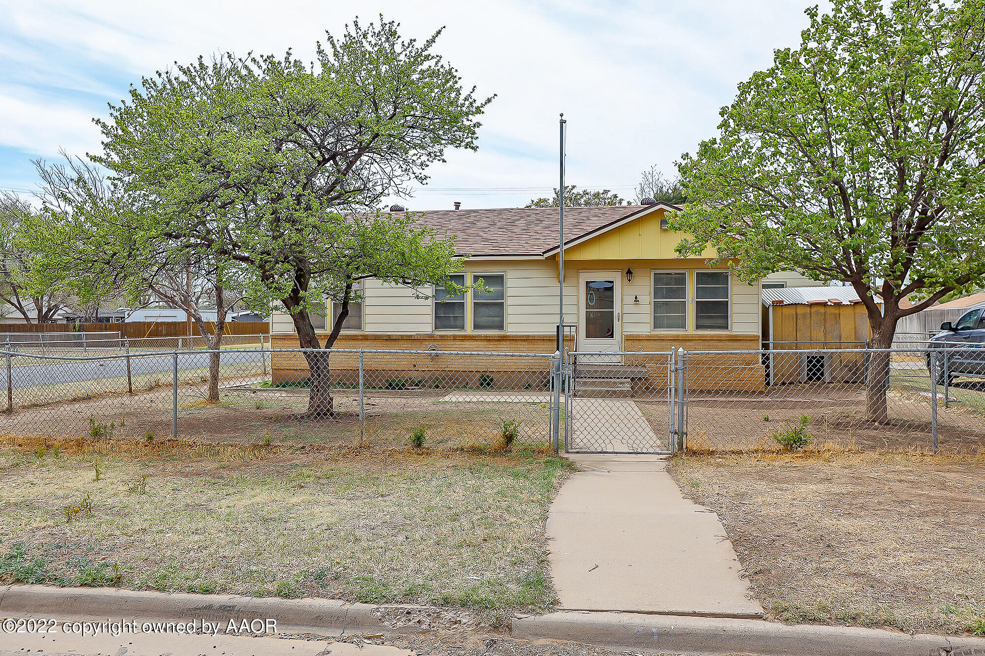 4318 South Hughes Street Amarillo, TX 79110 - Photo 1 of 25 a view of a white house next to a yard with large trees