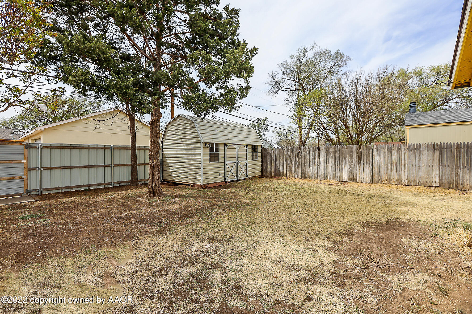 4318 South Hughes Street Amarillo, TX 79110 - Photo 22 of 25 a backyard of a house with large trees and wooden fence