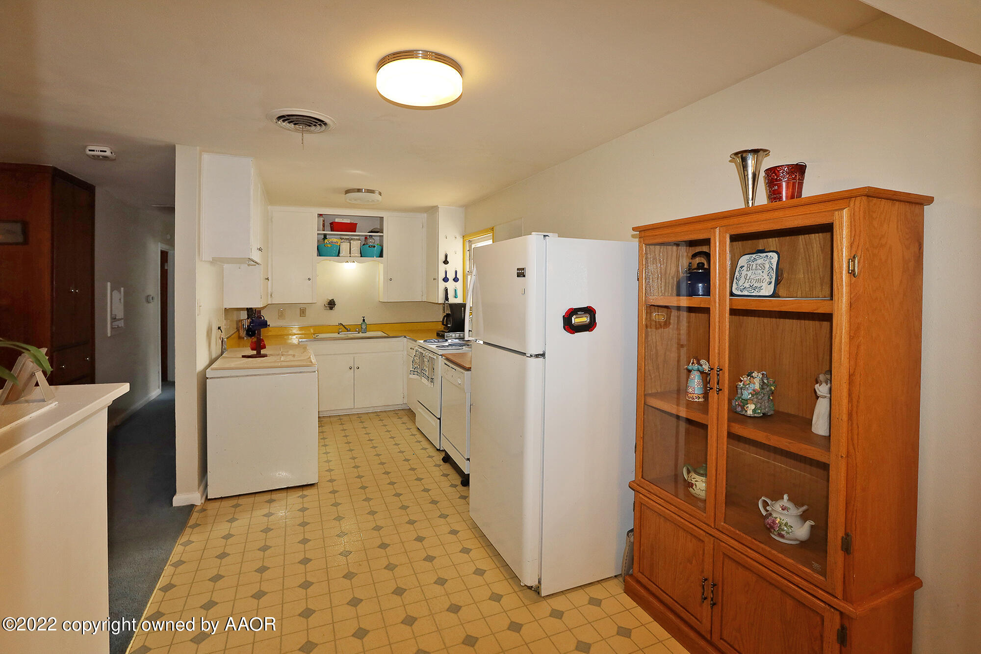 4318 South Hughes Street Amarillo, TX 79110 - Photo 8 of 25 a kitchen with a refrigerator a stove top oven and a sink