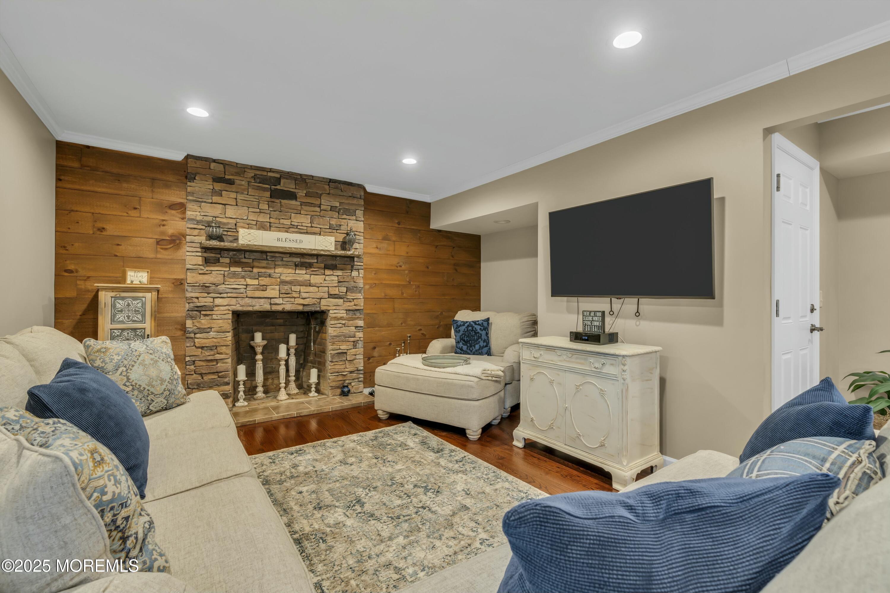 16 Glenarden Drive Howell, NJ 07731 - Photo 17 of 63 a living room with furniture a flat screen tv and a fireplace