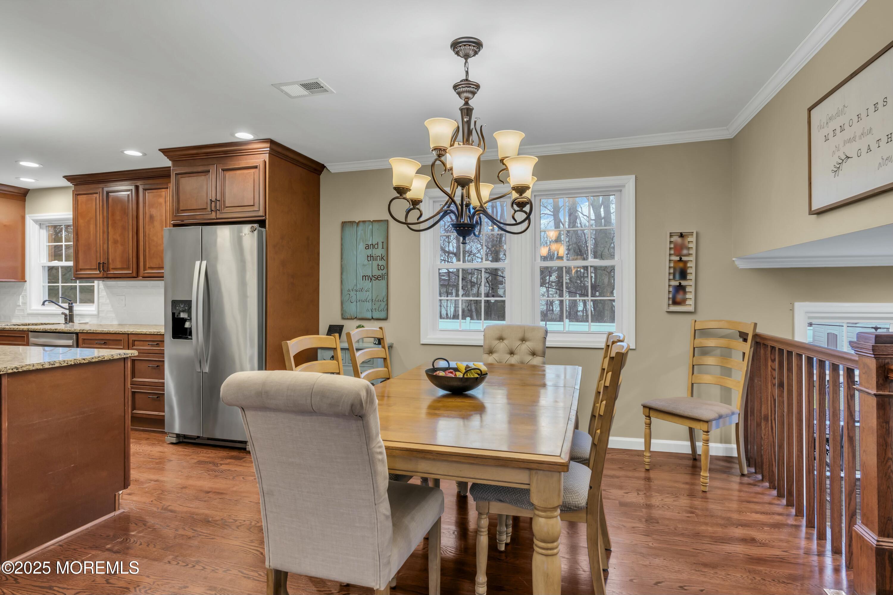 16 Glenarden Drive Howell, NJ 07731 - Photo 28 of 63 a dining room with wooden floor a chandelier a wooden table and chairs