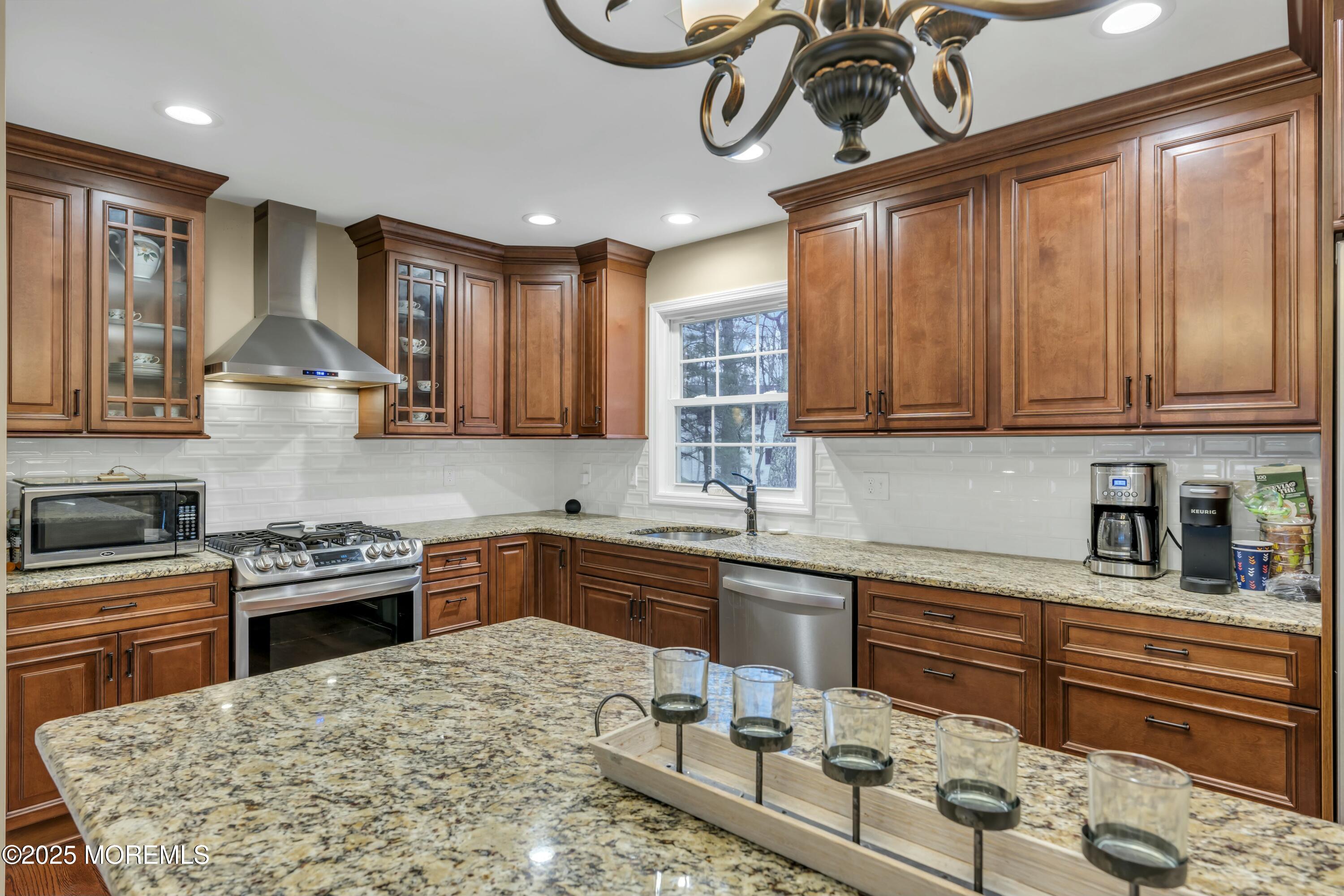 16 Glenarden Drive Howell, NJ 07731 - Photo 35 of 63 a kitchen with stainless steel appliances granite countertop a sink a stove a oven a dining table and chairs with wooden floor