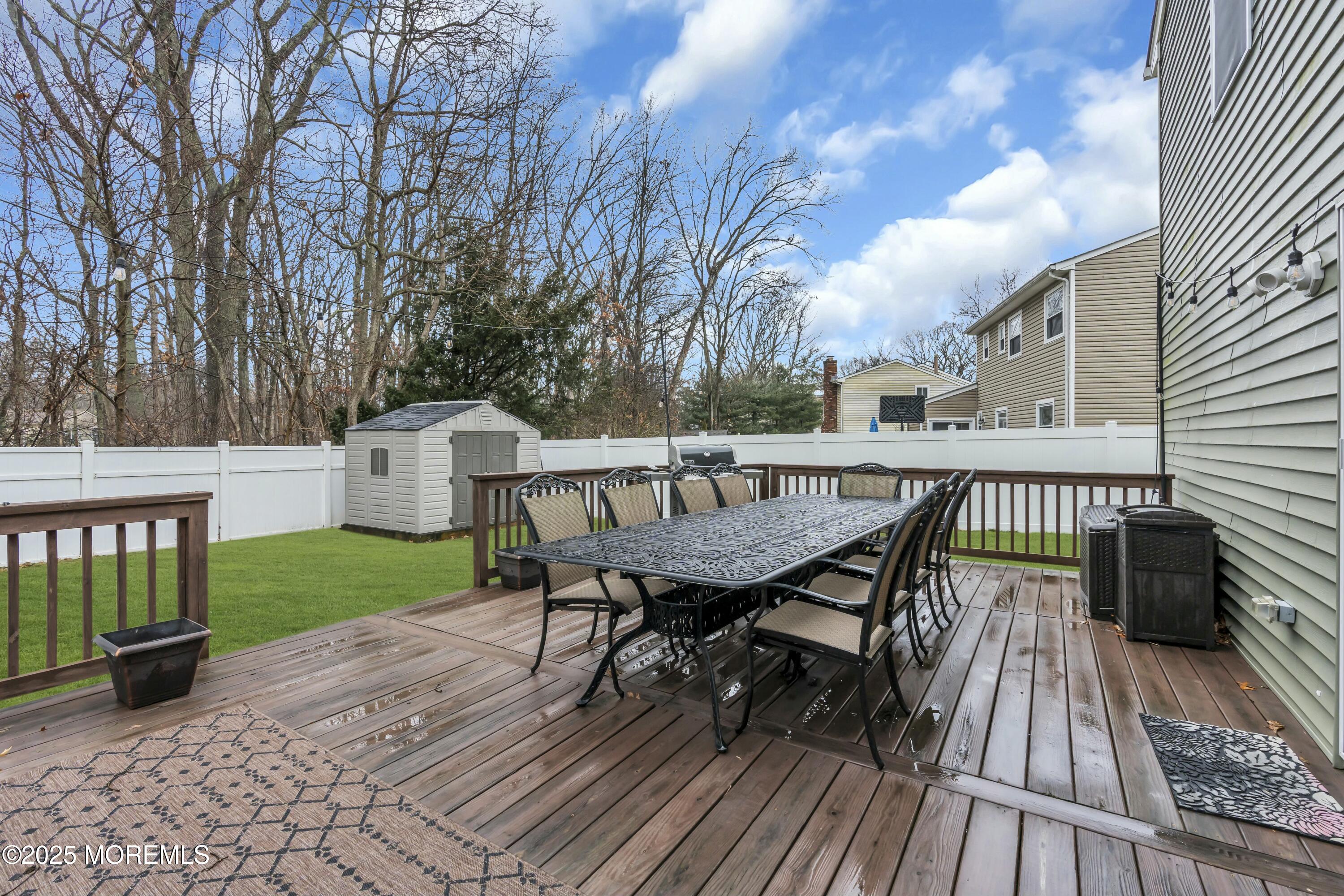 16 Glenarden Drive Howell, NJ 07731 - Photo 54 of 63 a view of a roof deck with table and chairs floor to ceiling window with wooden floor