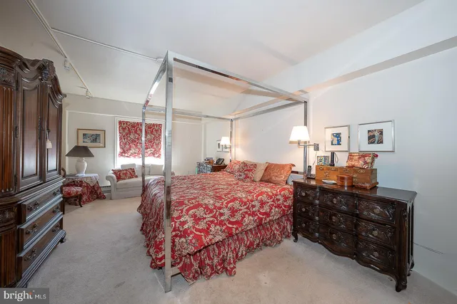 a bedroom with a bed window and dresser