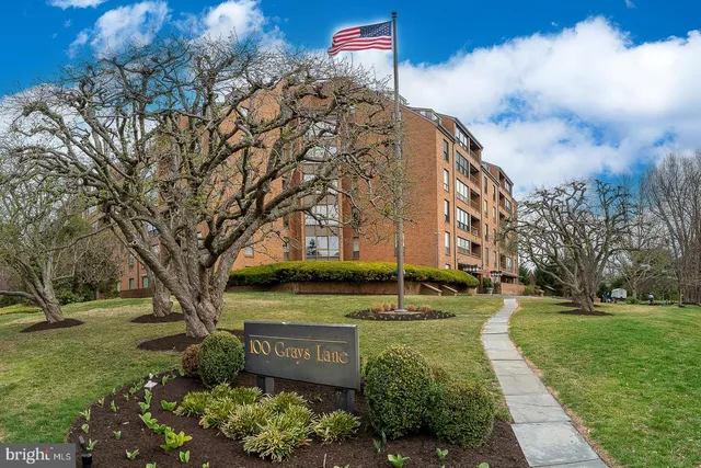 a sign board with tree in the background
