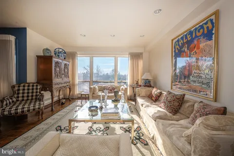 a living room with furniture large window and a table