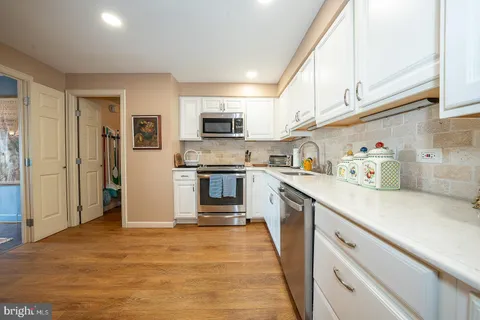 a kitchen with kitchen island a sink stainless steel appliances and cabinets