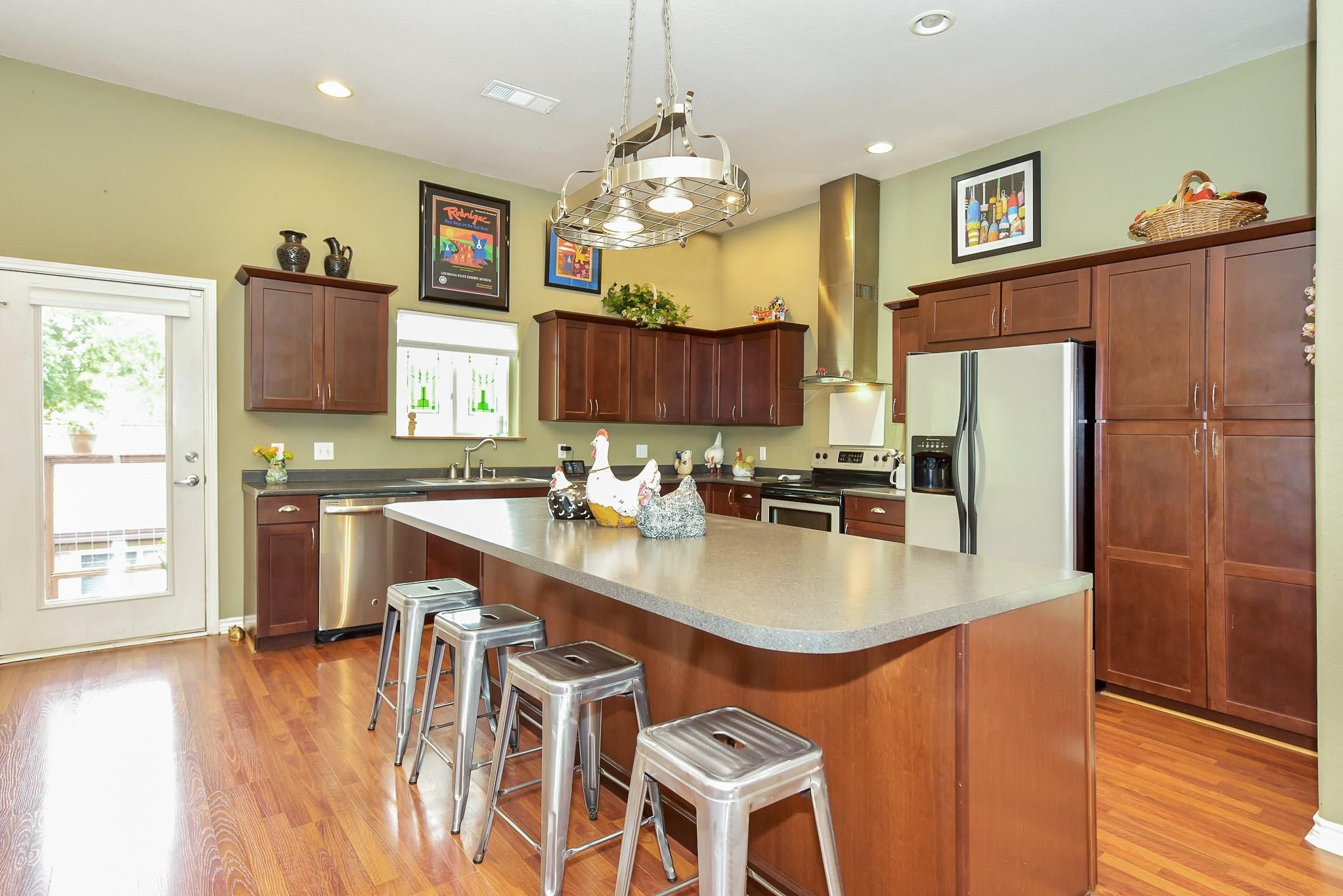 226 Valmar Kemah, TX 77565 - Photo 11 of 29 a kitchen with stainless steel appliances granite countertop a refrigerator a sink dishwasher a dining table and chairs with wooden floor