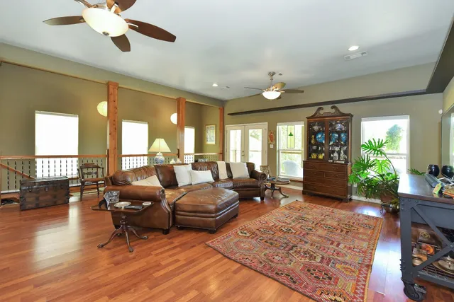 a view of a dining room and livingroom with furniture wooden floor a chandelier