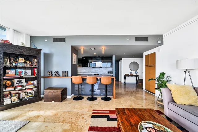 a living room with furniture flat screen tv and bookshelf