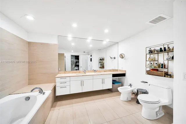 a bathroom with a bathtub toilet sink and mirror