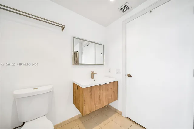 a bathroom with a sink mirror vanity and toilet