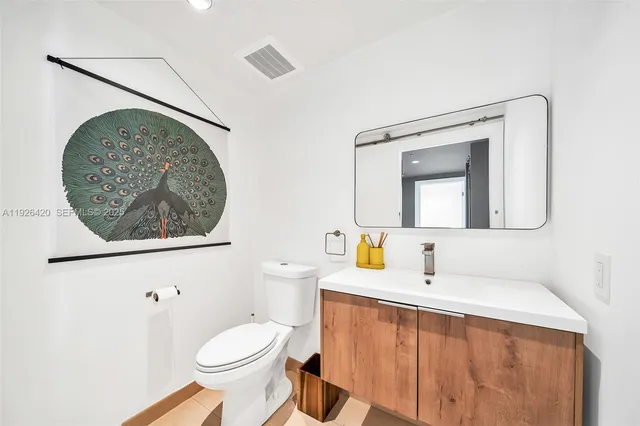 a bathroom with a sink a toilet and mirror