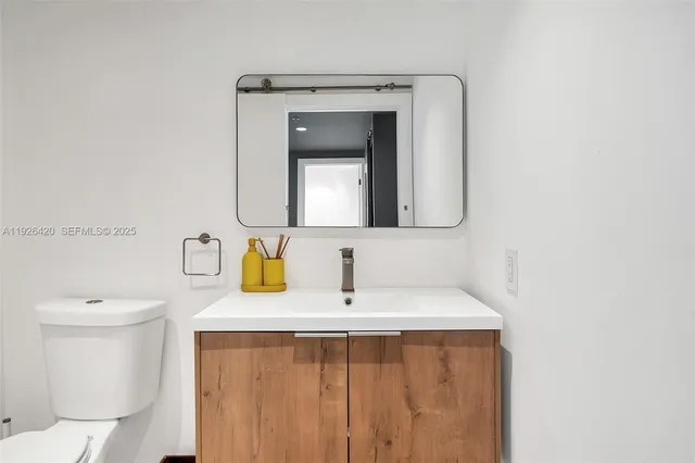 a bathroom with a toilet sink and mirror
