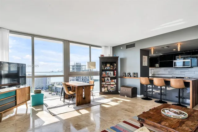 a living room with furniture a flat screen tv and a floor to ceiling window or kitchen