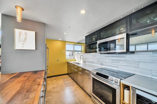 a kitchen with stainless steel appliances and wooden floor