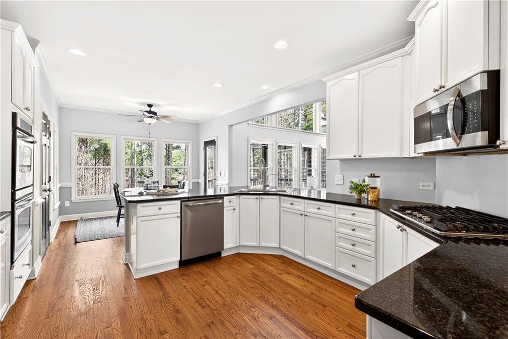 167 Calming Water Trail Dallas, GA 30132 - Photo 19 of 64 a kitchen with stainless steel appliances granite countertop wooden cabinets a stove a sink and a microwave