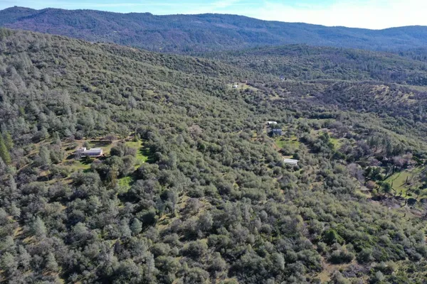 a view of a dry yard with mountains in the background