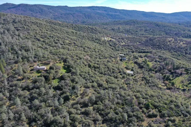a view of a dry yard with mountains in the background
