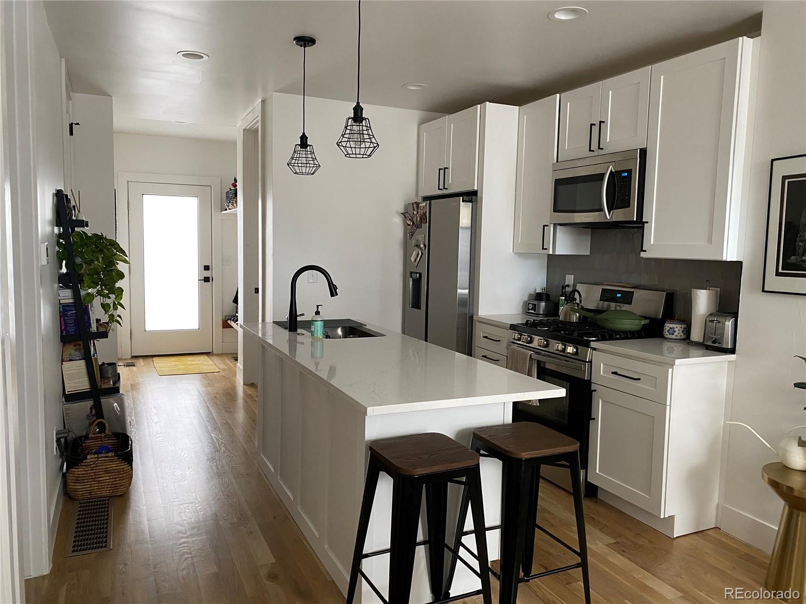 443 Inca Street Denver, CO 80204 - Photo 3 of 13 a kitchen with stainless steel appliances granite countertop a sink a stove and a refrigerator