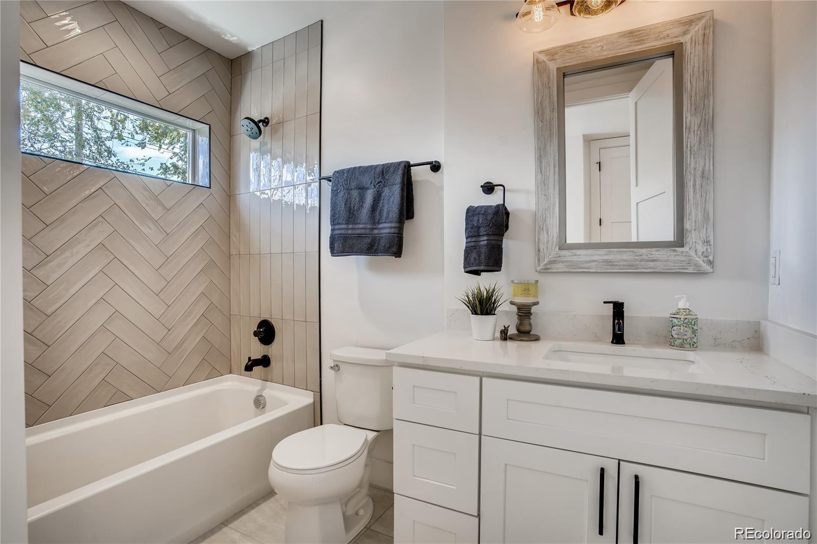 443 Inca Street Denver, CO 80204 - Photo 9 of 13 a bathroom with a toilet a sink a tub and a mirror