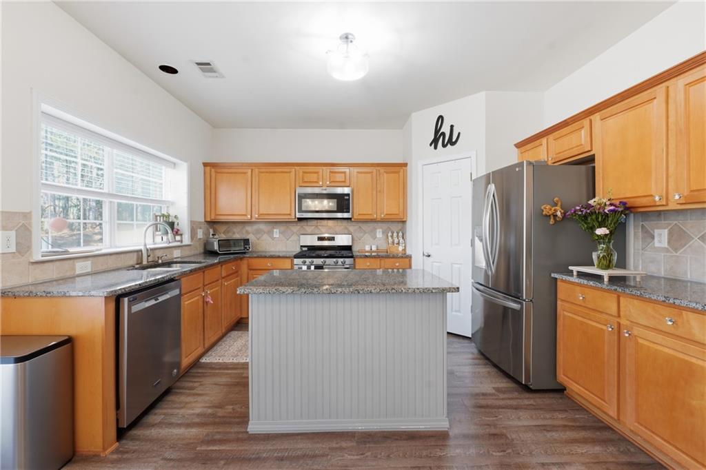 38 Crystal Downs Way Northeast Suwanee, GA 30024 - Photo 11 of 44 a kitchen with stainless steel appliances a refrigerator and a stove top oven