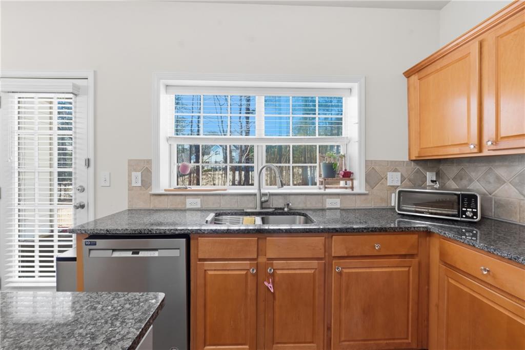 38 Crystal Downs Way Northeast Suwanee, GA 30024 - Photo 13 of 44 a kitchen with granite countertop cabinets sink and window