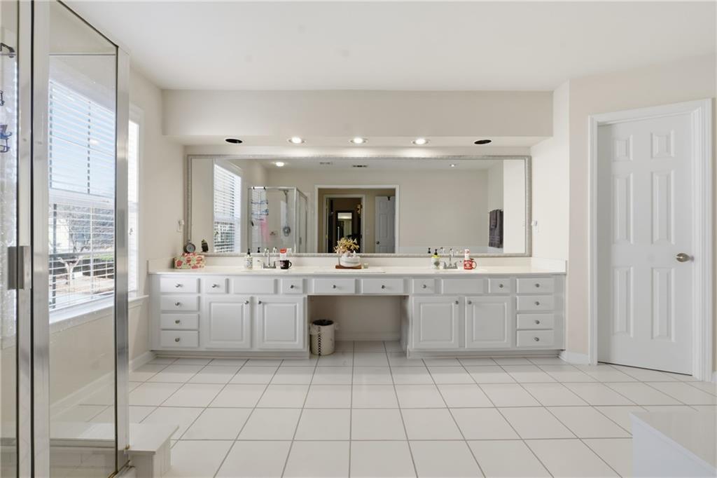 38 Crystal Downs Way Northeast Suwanee, GA 30024 - Photo 27 of 44 a large bathroom with a large mirror vanity and tub